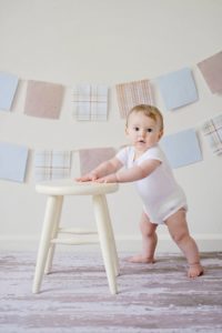 baby standing alone with hands on support